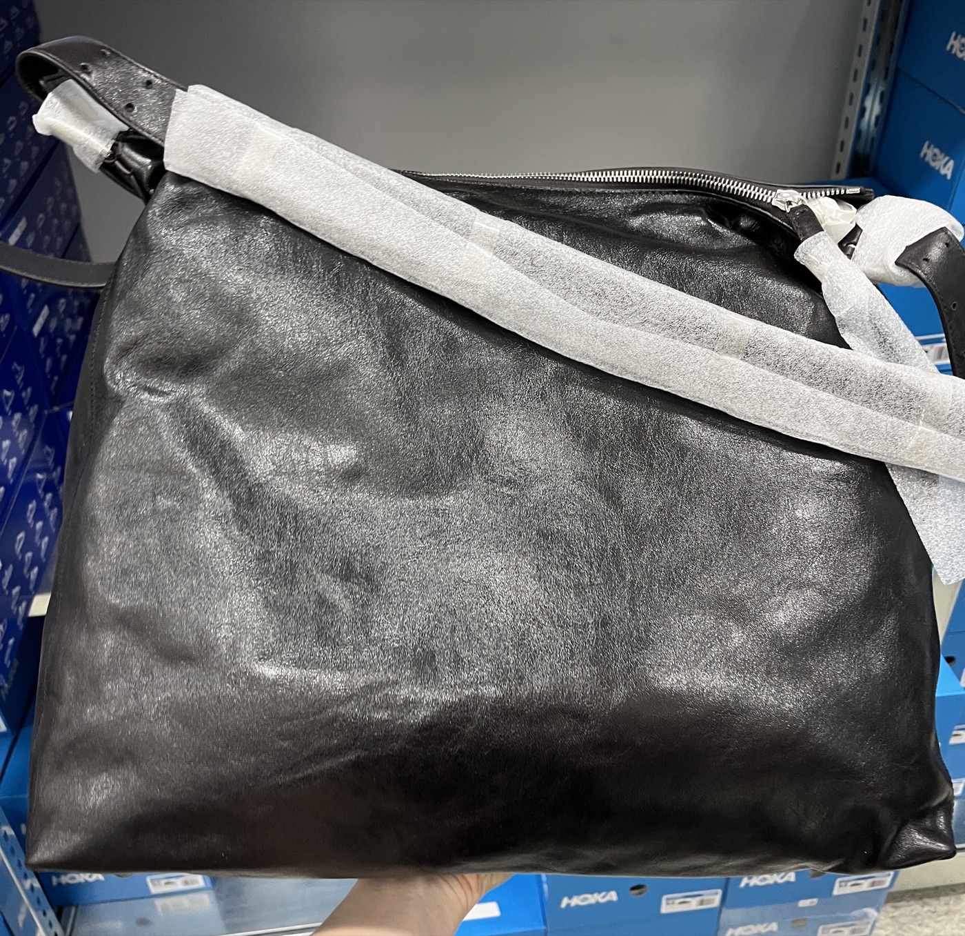 Inspecting a leather bag in the stockroom